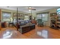 Spacious main bedroom with a four-poster bed, hardwood floors, and a ceiling fan at 3634 Apfel Rd, Wesley Chapel, FL 33543