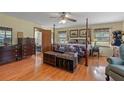 Comfortable main bedroom with an ensuite bathroom, four-poster bed, and hardwood floors at 3634 Apfel Rd, Wesley Chapel, FL 33543