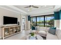 Comfortable living room featuring large windows with picturesque views, modern decor, and access to the patio at 6233 Plateau Ct, Bradenton, FL 34203