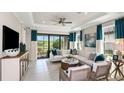 Spacious living room with modern furnishings, a ceiling fan, and views of the backyard at 6233 Plateau Ct, Bradenton, FL 34203