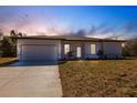 Charming single-story home featuring a two-car garage, manicured lawn, and a light and bright facade at 13089 Xavier Ave, Port Charlotte, FL 33981