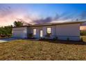 Charming single-story home featuring a two-car garage, manicured lawn, and a light and bright facade at 13089 Xavier Ave, Port Charlotte, FL 33981