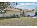 Exterior shot of the house shows a manicured lawn, side fence, and blue front door at 3019 Woodpine Ln, Sarasota, FL 34231