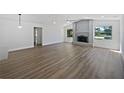 Open living room with a fireplace, light-colored walls, and wood-look floors at 3010 Pine Club Dr, Plant City, FL 33566