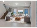 Inviting living room featuring neutral furniture, large windows, and a staircase at 5954 Caldera Ridge Dr, Lithia, FL 33547