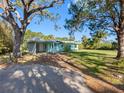 Charming single-story home with a well-maintained lawn and mature trees in a peaceful setting at 5275 Miller Bayou Dr, Port Richey, FL 34668