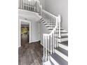 Bright foyer featuring a staircase with white wood railings, dark wood treads and hardwood floors at 13794 Marseilles Ct, Clearwater, FL 33762
