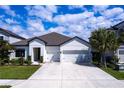 Beautiful single-story home featuring a three car garage, manicured lawn, and crisp white exterior paint at 16524 Paynes Mill Dr, Bradenton, FL 34211