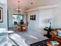 Open-concept dining area with wood table, chandelier, and sliding door access at 4845 Post Pointe Dr, Sarasota, FL 34233