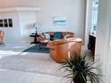 Inviting living room featuring neutral walls, a comfortable leather sofa and light-filled window at 4845 Post Pointe Dr, Sarasota, FL 34233