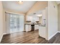 Open concept kitchen features granite countertops, white cabinets and luxury vinyl plank flooring at 7001 Heath Dr, Port Richey, FL 34668