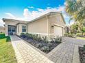 Lovely exterior showcasing the attached garage and well-manicured landscaping at 4949 Sandy Glen Way, Wimauma, FL 33598