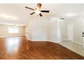 Open concept living area with hardwood floors, a ceiling fan, and tile entrance at 8147 Matthew Dr, New Port Richey, FL 34653