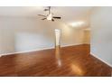 Spacious living room with gleaming hardwood floors and modern ceiling fan at 8147 Matthew Dr, New Port Richey, FL 34653