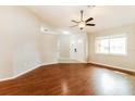 Inviting living room featuring hardwood floors, a ceiling fan, and a bright window at 8147 Matthew Dr, New Port Richey, FL 34653
