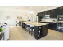 Modern kitchen featuring dark cabinetry and large center island with seating at 150 Castile Ct, Punta Gorda, FL 33983