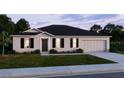 Single-story home featuring a well-manicured lawn, garage, and a classic front door at 469 Chubut Ct, Punta Gorda, FL 33983