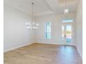 Bright and spacious living room with wood-look flooring, stylish chandeliers, and large windows at 5013 Sea Branch Ave, Apollo Beach, FL 33572