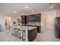 Modern kitchen with a large island, granite countertops, stainless steel appliances, and dark wood cabinets at 27210 Adams St, Punta Gorda, FL 33983