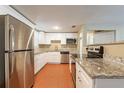 Bright kitchen featuring stainless steel appliances, granite countertops, and white cabinets at 3201 Cord St, Tampa, FL 33605
