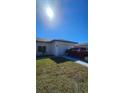 The house featuring a large garage and a neatly kept lawn, red truck parked in the driveway at 17065 Malta Ave Ave, Port Charlotte, FL 33954