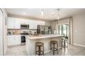 Modern kitchen featuring white cabinets, stainless steel appliances, granite countertops, and a central island with barstool seating at 2349 Broadpoint Dr, Punta Gorda, FL 33983