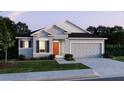 Inviting single-story home showcases a gray exterior, two-car garage, and lush lawn at 16449 Campo Sano Ct, Punta Gorda, FL 33955