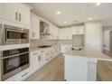 Modern kitchen with white cabinets, stainless steel appliances and bright lighting at 4914 Carova Way, Lakewood Ranch, FL 34211