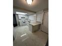 Updated kitchen featuring white cabinets, modern countertops, and a skylight at 6405 Gainsboro Dr, Port Richey, FL 34668
