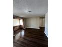 Bright living room with wood floors, a brick accent wall, and large windows at 6405 Gainsboro Dr, Port Richey, FL 34668