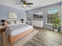 Bright bedroom with two windows, neutral paint, modern ceiling fan, and wood-look flooring at 1729 Nelda Ln, Sarasota, FL 34232