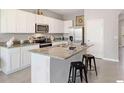 Well-lit kitchen with granite counters, stainless appliances, a center island, and breakfast bar at 32859 Pez Landing Ln, Wesley Chapel, FL 33543