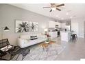 Bright living space with tile flooring, ceiling fan, modern furnishings, and open kitchen view at 32859 Pez Landing Ln, Wesley Chapel, FL 33543