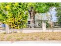 Landscaped yard and mature trees frame this single Gathering home with a fence offering privacy and curb appeal at 4218 E Paris St, Tampa, FL 33610