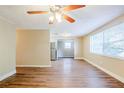 Bright living room featuring new laminate flooring, a ceiling fan, and lots of natural light at 4218 E Paris St, Tampa, FL 33610