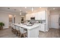 Bright kitchen featuring white cabinets, stainless steel appliances, large island with countertop dining, and pendant lighting at 25138 Calusa Dr, Punta Gorda, FL 33955