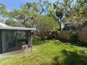 Lush backyard featuring a screened-in porch and privacy fence at 4906 W Cleveland St, Tampa, FL 33609