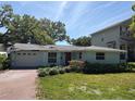 Charming single-story home with a brick driveway and mature landscaping at 4906 W Cleveland St, Tampa, FL 33609