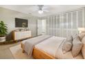 Bright bedroom with a large bed, ceiling fan, and a TV above a wooden dresser at 513 Flamingo Dr, Apollo Beach, FL 33572