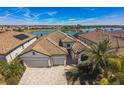Aerial view of a beautiful home with a tile roof and a lake view in the background at 17936 Polo Trl, Bradenton, FL 34211