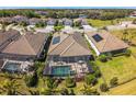 Aerial view of home with screened pool, solar panels, landscaping, and neighborhood at 17936 Polo Trl, Bradenton, FL 34211