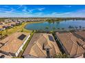 Wide aerial view of a home with solar panels and a scenic lake in the background at 17936 Polo Trl, Bradenton, FL 34211