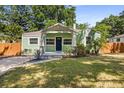 Charming green bungalow with a covered front porch, stone accents, and a well-maintained lawn at 1206 E Hamilton Ave, Tampa, FL 33604