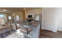 Eat-in kitchen island boasts barstool seating, granite countertops, and modern stainless steel appliances, connecting to the living room at 14725 Italy Ave, Dade City, FL 33523