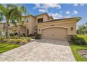 Beautiful two-story home with a three-car garage and a well-manicured lawn and landscape at 2709 Coco Palm Cir, Wesley Chapel, FL 33543