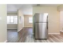 Open-concept living space with wood-look floors and natural light; stainless steel refrigerator on right at 6730 32Nd N Ave, St Petersburg, FL 33710