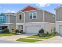 Exterior view of a home showcasing its well-kept lawn and two car garage at 7617 Wallflower Trl, Wesley Chapel, FL 33545