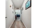 Inviting hallway with wood flooring and tasteful decor leading into the living spaces at 7617 Wallflower Trl, Wesley Chapel, FL 33545