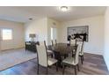 Dining room featuring luxury vinyl plank flooring, contemporary artwork, and an adjacent living area at 36137 Canelli Way, Dade City, FL 33523