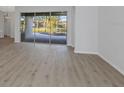 Spacious living area featuring wood-look floors and sliding glass doors to the lanai at 6741 64Th E Ter, Bradenton, FL 34203